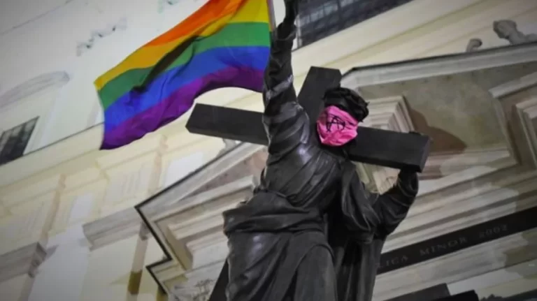 Kip Isusa oskrnavljen LGBT zastavom u duginim bojama i anarhističkom simbolom